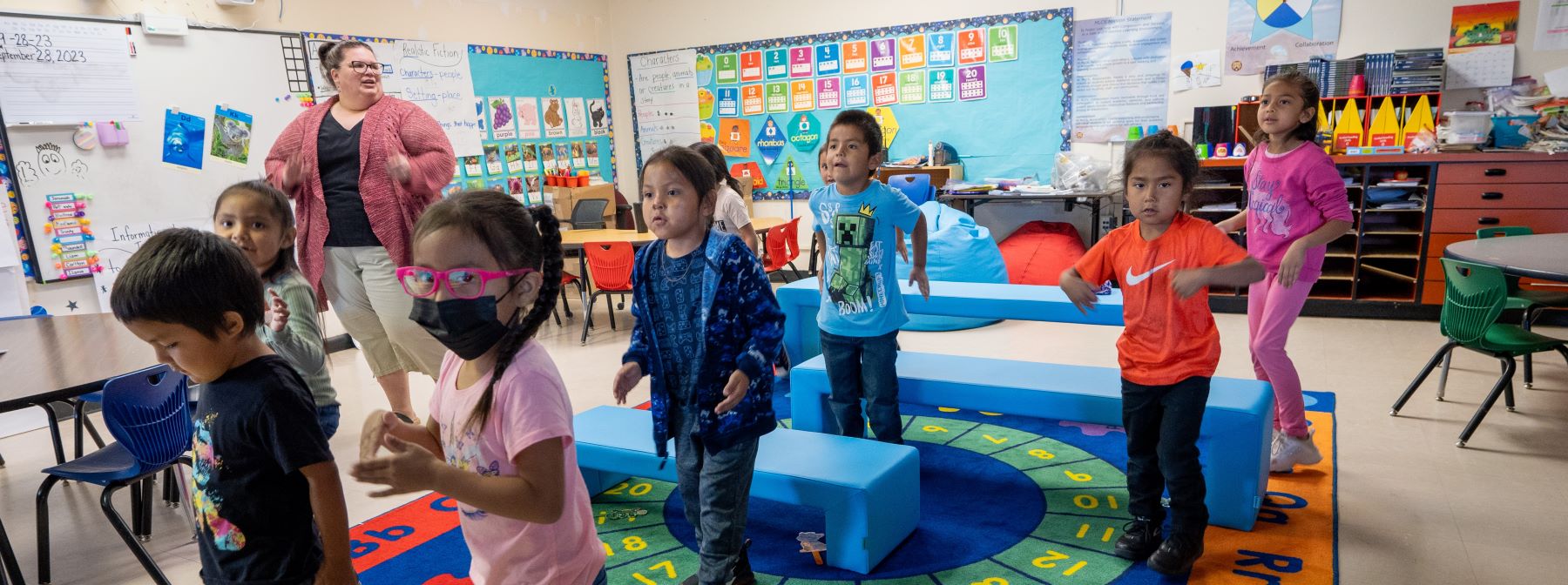 Teacher and students up and moving in classroom